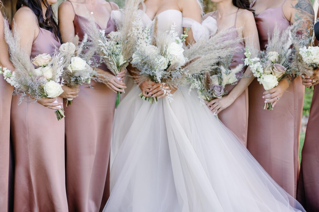 beautiful bridal and bridesmaids bouquets full of roses and pampas grass.