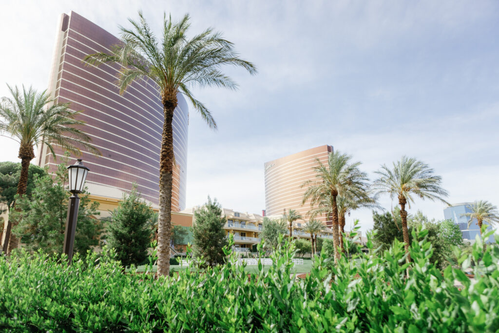Wynn Las Vegas wedding venue filled with palm trees, green grass, and tall building