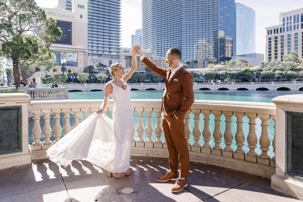 A couple twirling in front of the Bellagio fountain at a Bellagio Wedding